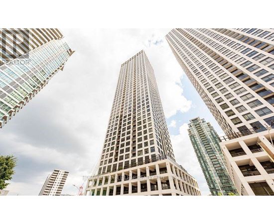 A cityscape with tall buildings and a cloudy sky.