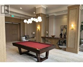 A pool table in a room with a green plant on the side.