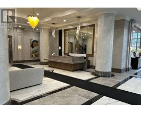 A spacious lobby with marble floors and a large chandelier.