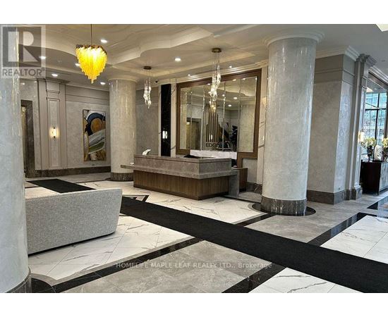 A spacious lobby with marble floors and a large chandelier.