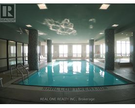 A large indoor swimming pool with the words "Shallow Area" written on the bottom.