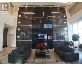 A modern living room with a large TV and comfortable seating.