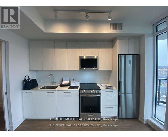A kitchen with white cabinets and a black stove top oven.