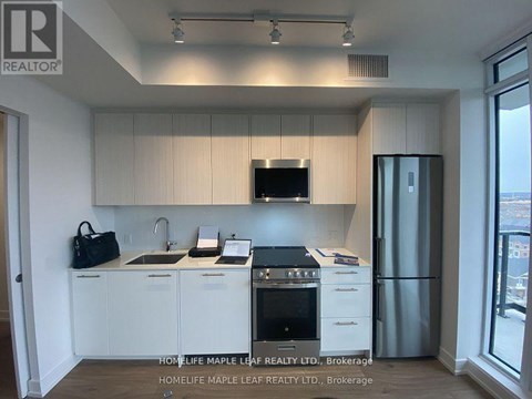 A kitchen with white cabinets and a black stove top oven.
