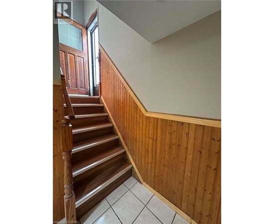 A wooden staircase with a white tiled floor.