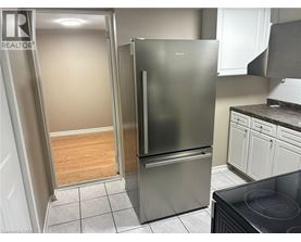 A kitchen with a refrigerator and a stove top oven.
