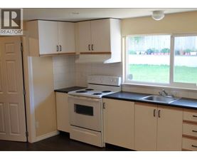 A kitchen with white cabinets and a black countertop.