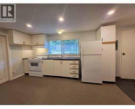 A kitchen with white appliances and cabinets is for sale.