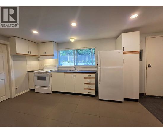 A kitchen with white appliances and cabinets is for sale.