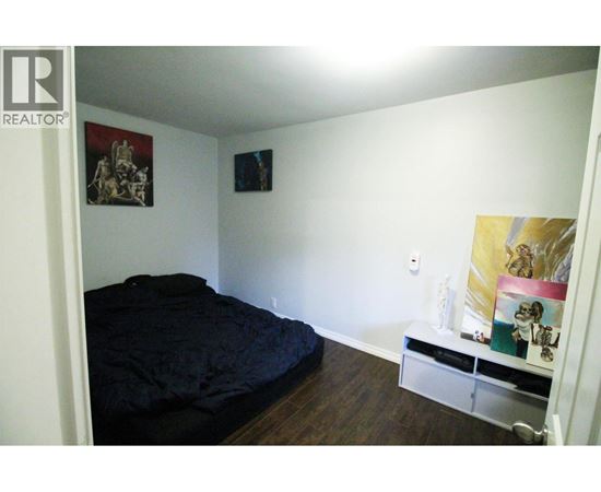 A bedroom with a bed, a shelf, and pictures on the wall.