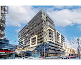 A large, modern building with many windows and balconies is under construction.