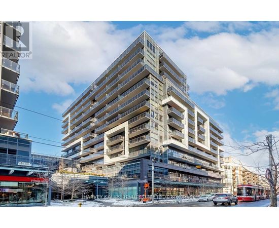 A large, modern building with many windows and balconies is under construction.