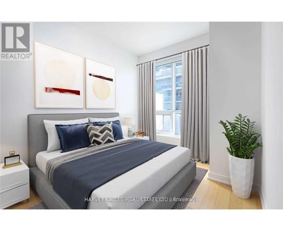 A bedroom with a large bed and a potted plant.