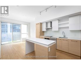 A kitchen with a white counter top and wooden cabinets.