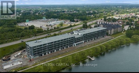 An aerial view of a large building complex with a body of water in front of it.