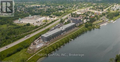 An aerial view of a large building complex with a body of water in front of it.