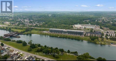 A real estate company logo is superimposed on a scenic aerial view of a river and a cityscape.