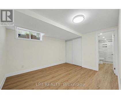 A room with wooden flooring and a window with blinds.