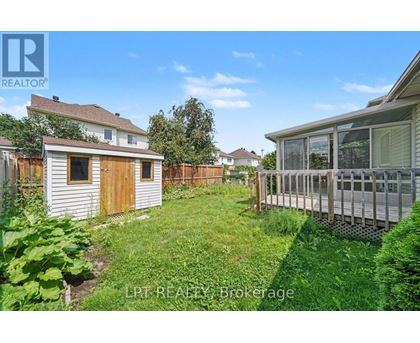 A backyard with a wooden fence and a small shed.