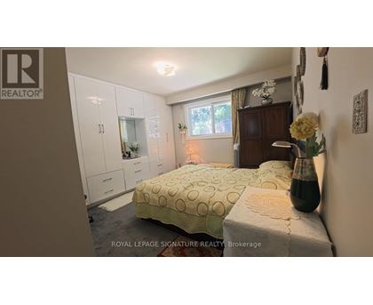 A bedroom with a bed, a dresser, and a window.