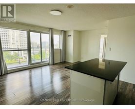 A room with a black countertop and wooden flooring.