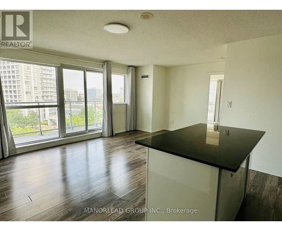 A room with a black countertop and wooden flooring.