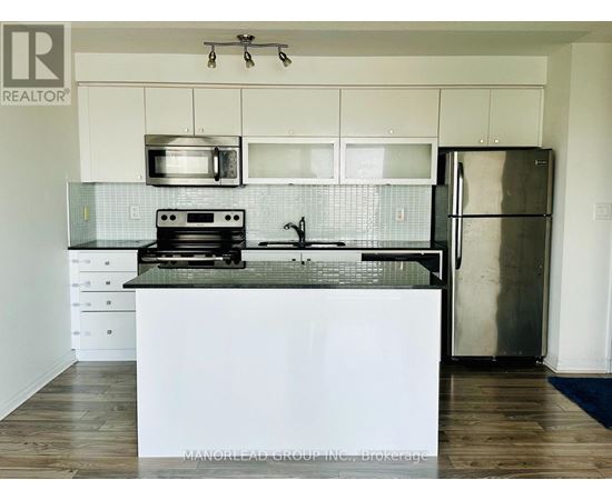 A kitchen with a white counter top and stainless steel appliances.
