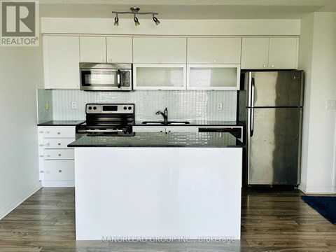 A kitchen with a white counter top and stainless steel appliances.