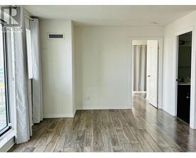 A room with wooden flooring and white walls.