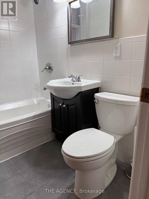 A white toilet sits next to a sink in a bathroom.