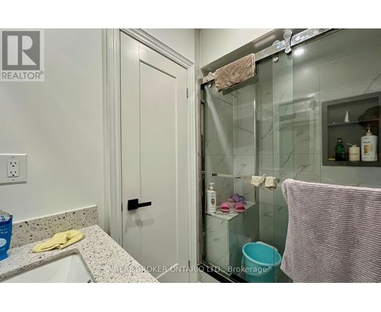 A bathroom with a glass shower door and a white sink.