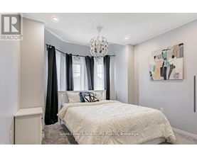 A bedroom with a large bed and a chandelier.