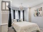 A bedroom with a large bed and a chandelier.