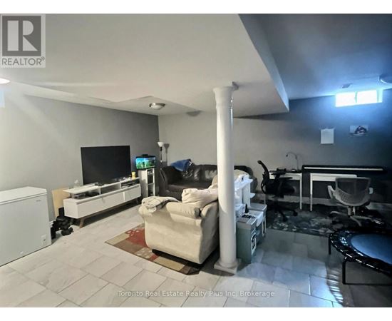 A living room with a white couch and a television.