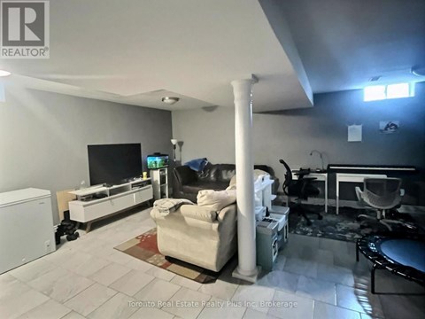 A living room with a white couch and a television.