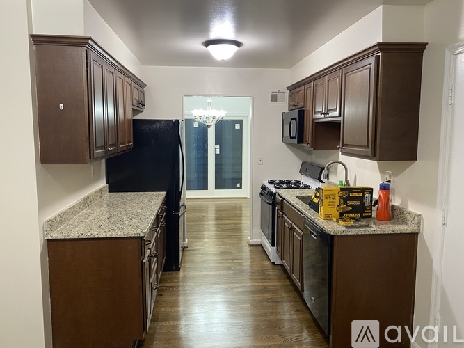 A kitchen with dark wood cabinets and granite countertops.