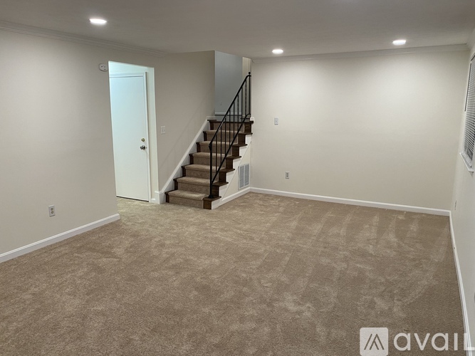 A spacious room with a staircase leading to the upper floor.