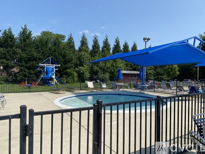 A pool area with a slide and a blue canopy.