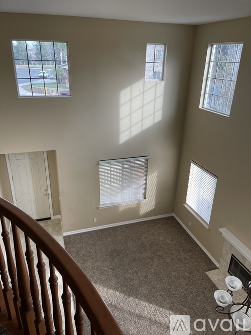 A living room with a carpeted floor and a fireplace.