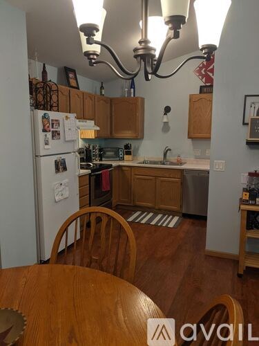 A kitchen with wooden cabinets and a white fridge.