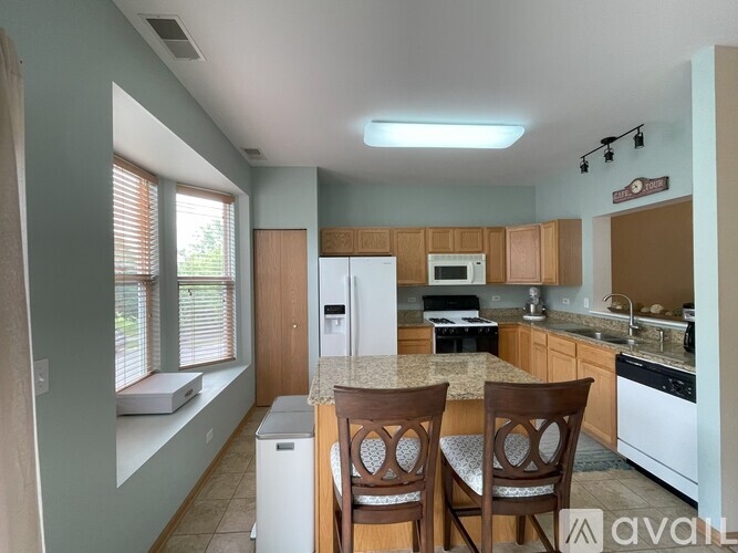 A kitchen with a table and chairs in front of it.