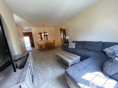 A living room with a grey couch and a wooden coffee table.