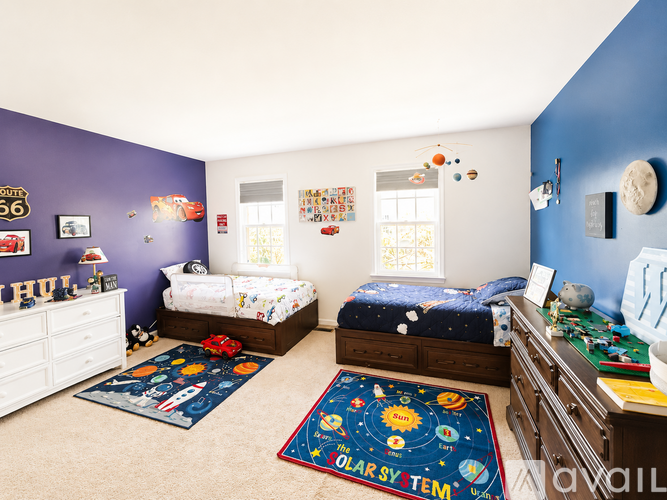 A bedroom with two beds and a dresser.