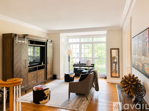 A living room with a grey couch and a wooden cabinet.