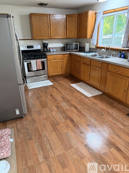 A kitchen with wooden floors and a refrigerator.