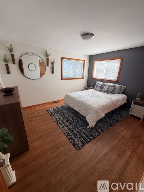A bedroom with a bed, a dresser, and a mirror on the wall.