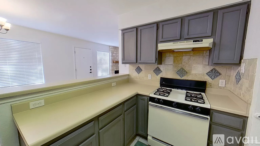 A kitchen with a stove top oven and cabinets.