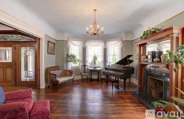 A living room with a piano and a fireplace.