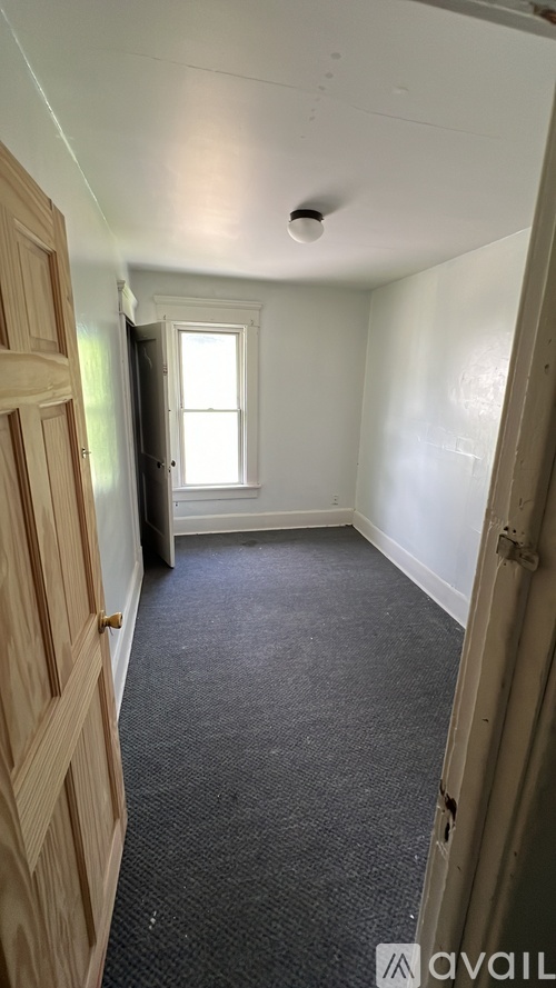 A room with a carpeted floor and a window.