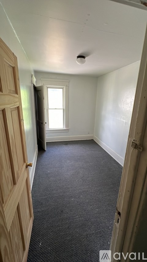 A room with a carpeted floor and a window.